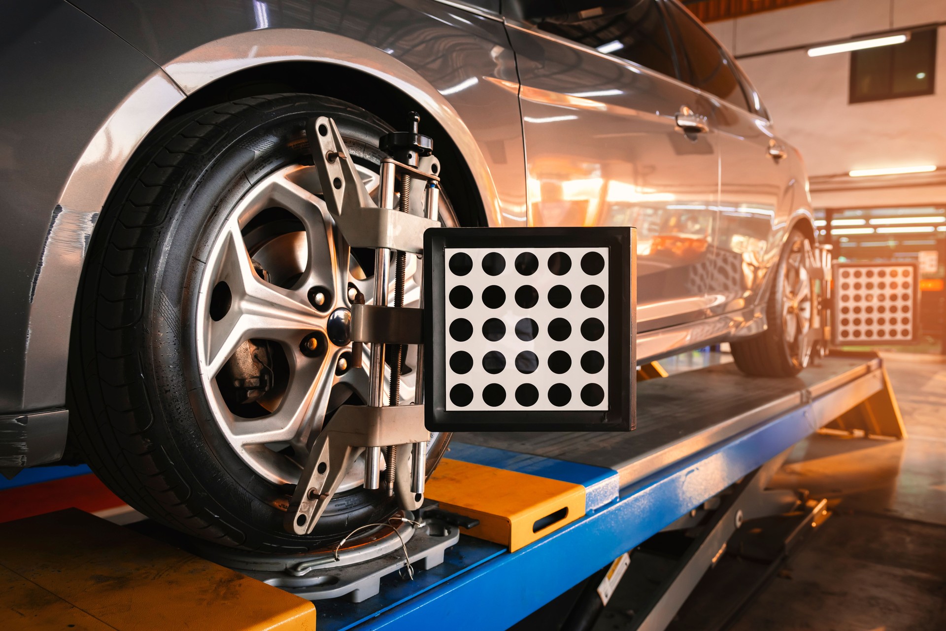 Car wheel alignment is in progress. auto camber toe check fixing. sensor during suspension adjustment and automobile wheel alignment work at the repair service station